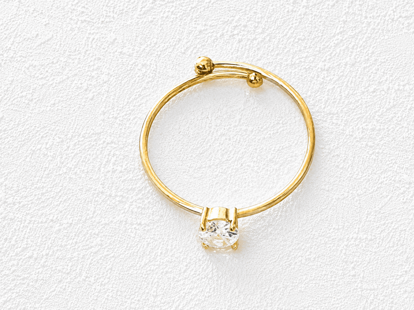 LUCERO DE TIJARAFE · Anillo abierto ajustable en oro fino con cristal redondo en garra y remates de bola.