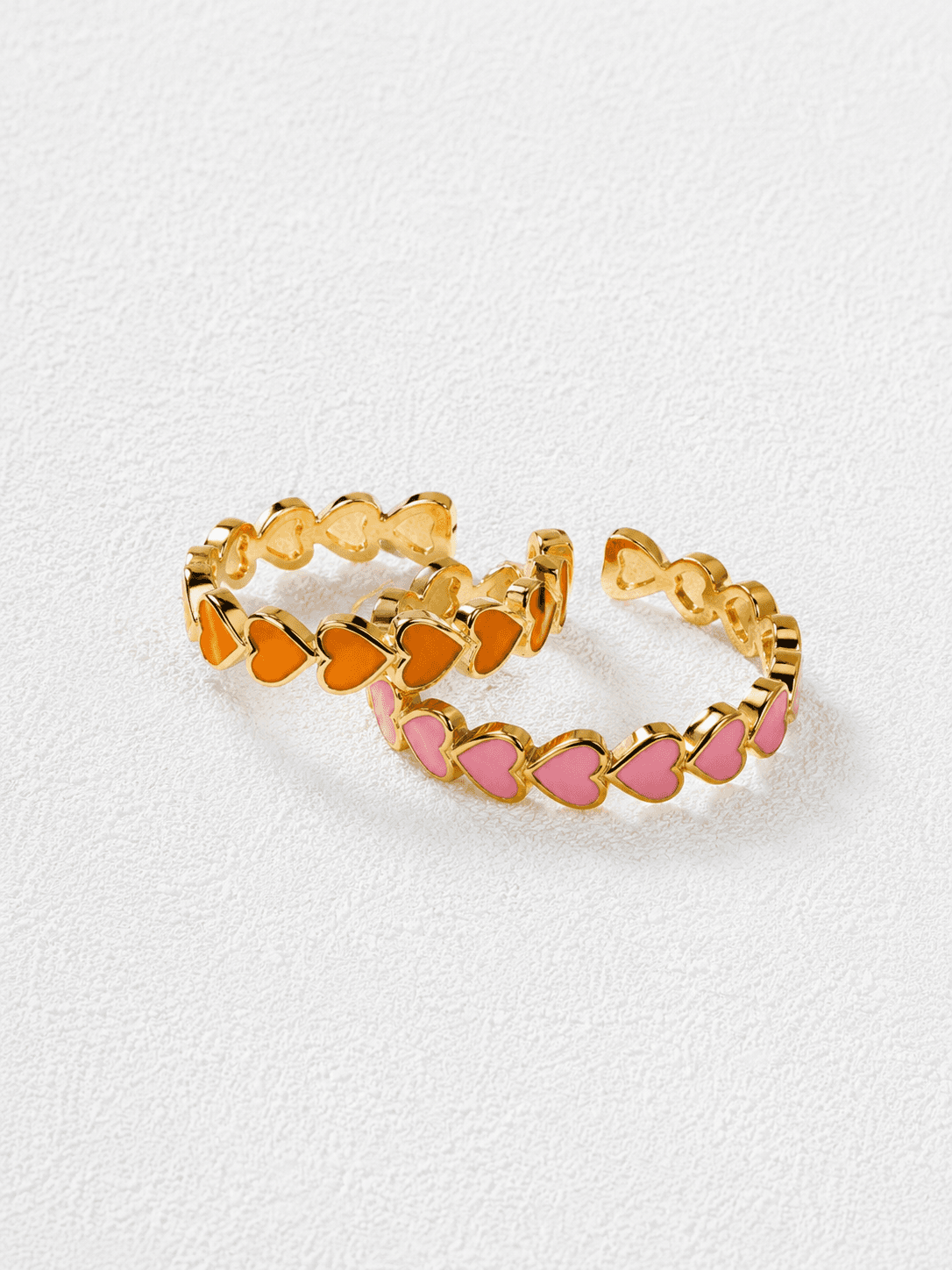 CORAZÓN DE MASÍA · Anillos abiertos de corazones en esmalte naranja y rosa con baño en oro